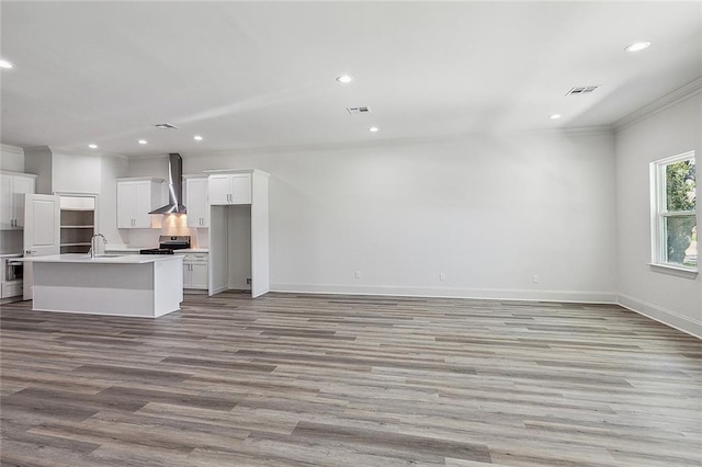 unfurnished living room featuring ornamental molding, sink, and light hardwood / wood-style flooring