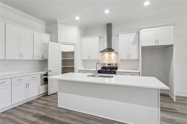 kitchen featuring sink, a kitchen island with sink, white cabinets, wall chimney exhaust hood, and light wood-type flooring