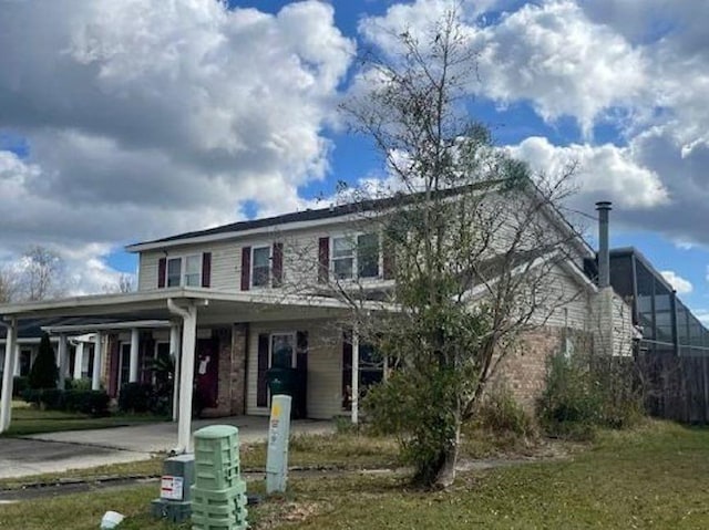 view of front of house with brick siding, concrete driveway, and a front lawn