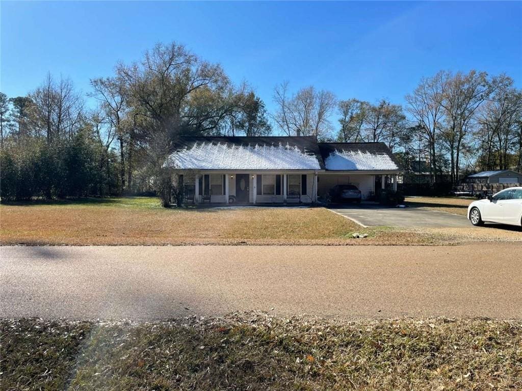 ranch-style house with a front yard and a carport