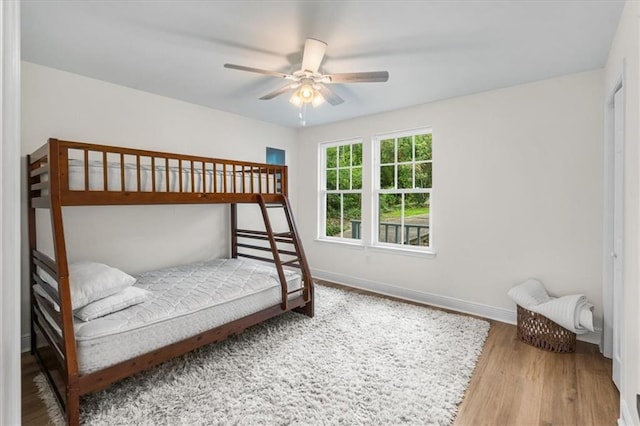 bedroom featuring a ceiling fan, wood finished floors, and baseboards
