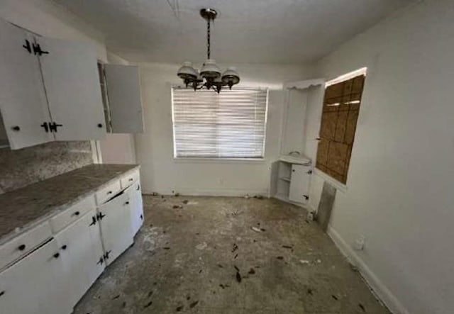 kitchen featuring white cabinetry, a notable chandelier, and decorative light fixtures