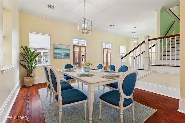 dining space featuring dark hardwood / wood-style flooring, a notable chandelier, and ornamental molding