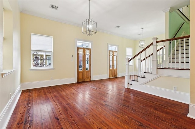 foyer with an inviting chandelier, ornamental molding, and hardwood / wood-style flooring