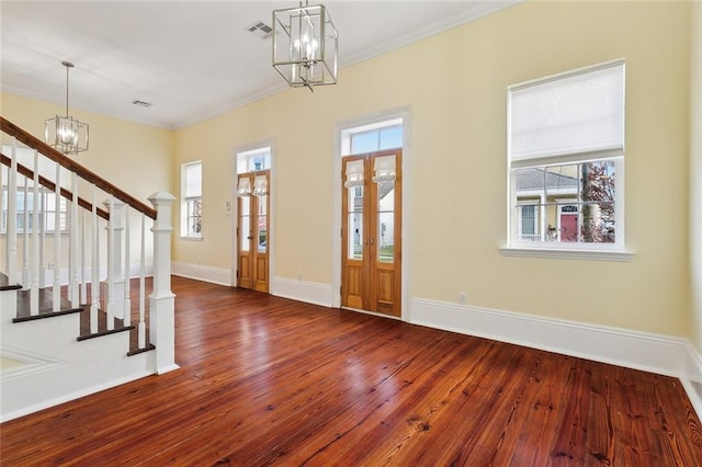 entrance foyer with hardwood / wood-style floors and an inviting chandelier