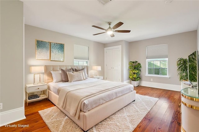 bedroom featuring hardwood / wood-style flooring, ceiling fan, and a closet