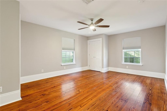 unfurnished bedroom featuring ceiling fan, wood-type flooring, and a closet