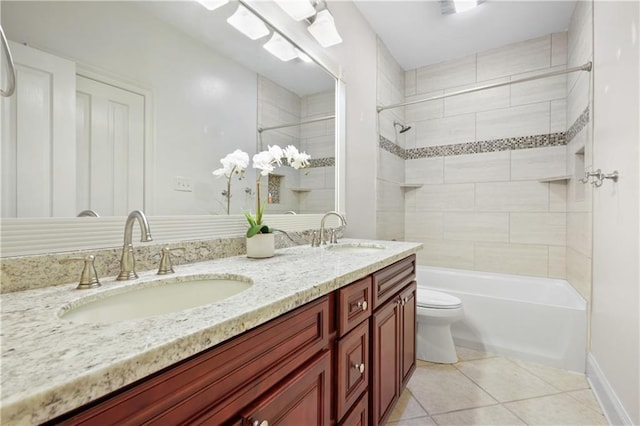 full bathroom featuring tile patterned flooring, vanity, tiled shower / bath, and toilet