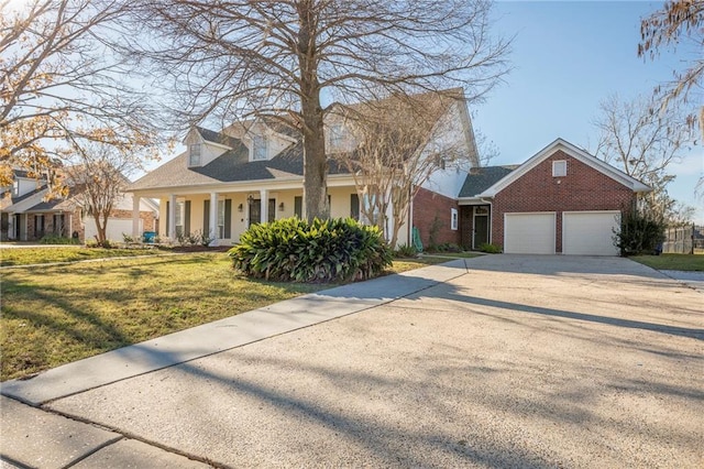 new england style home with a porch, a garage, and a front yard