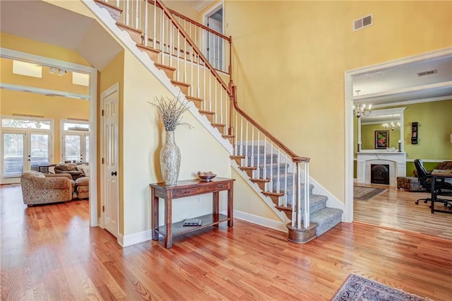 staircase with hardwood / wood-style flooring, french doors, and a high ceiling