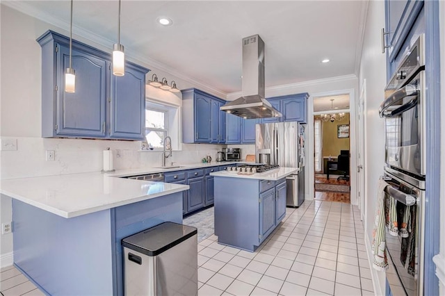 kitchen with appliances with stainless steel finishes, pendant lighting, island range hood, sink, and kitchen peninsula