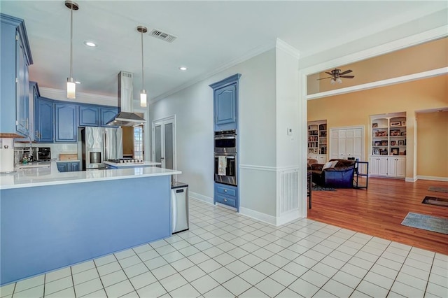 kitchen with built in shelves, island exhaust hood, ornamental molding, and decorative light fixtures