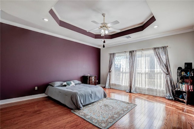 bedroom with crown molding, a tray ceiling, and ceiling fan