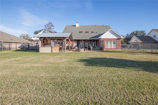 rear view of house with a bar, area for grilling, a patio area, and a lawn