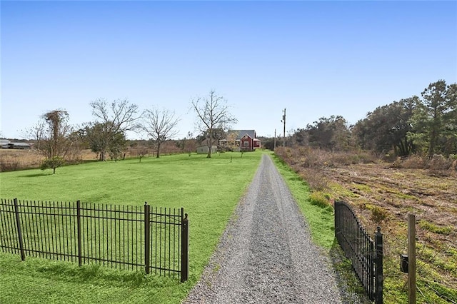 view of property's community with a rural view and a lawn