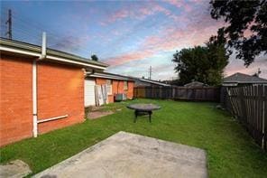 yard at dusk featuring a patio area