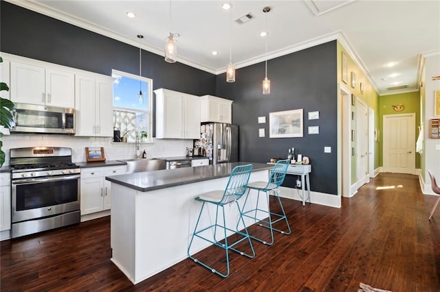 kitchen with stainless steel appliances, decorative light fixtures, and a center island