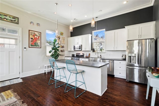 kitchen featuring sink, white cabinetry, hanging light fixtures, stainless steel appliances, and a center island