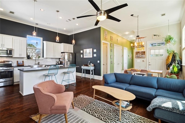 living room featuring crown molding, ceiling fan, and dark hardwood / wood-style floors