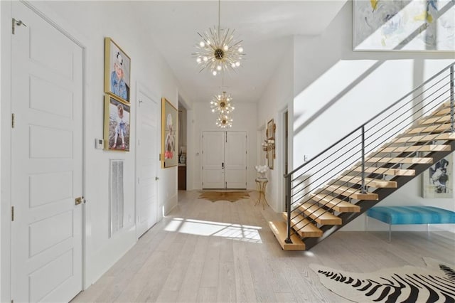 foyer with a notable chandelier and light wood-type flooring