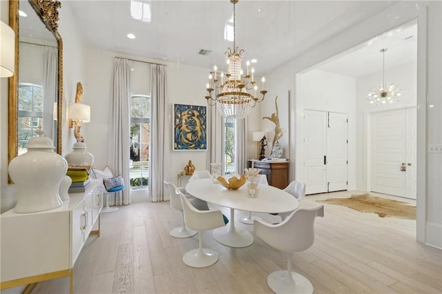 dining room featuring a notable chandelier and light wood-type flooring