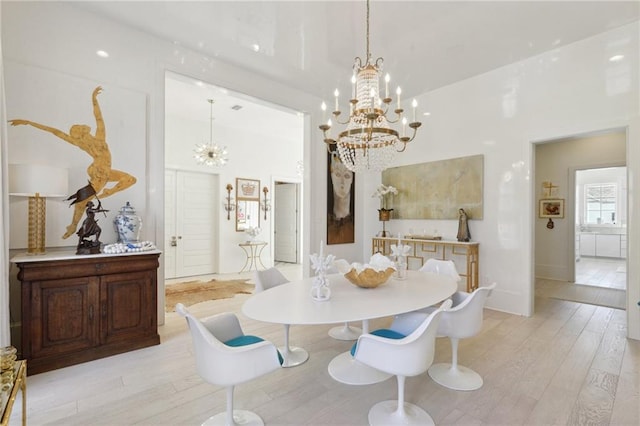 dining room with an inviting chandelier and light hardwood / wood-style flooring