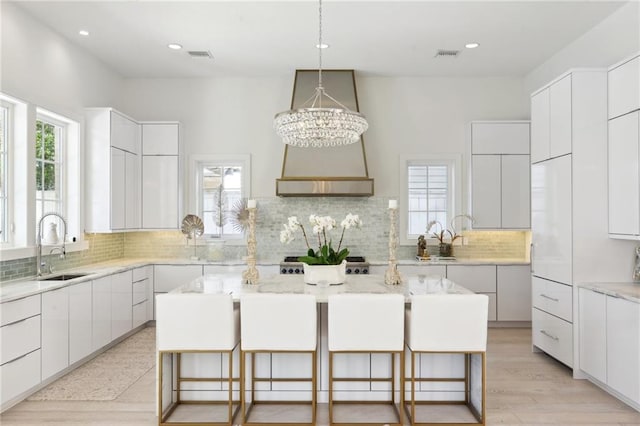 kitchen featuring white cabinetry, a center island, and a breakfast bar area