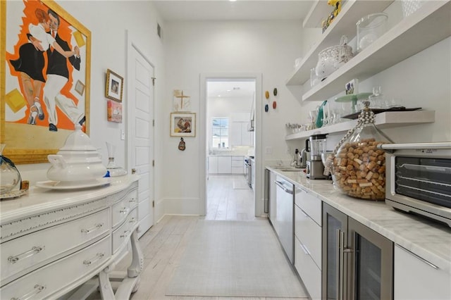 kitchen with sink, light hardwood / wood-style flooring, wine cooler, white cabinets, and stainless steel dishwasher