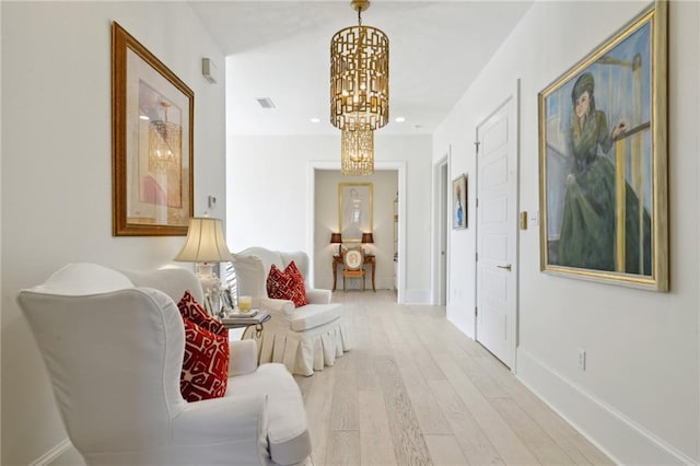 sitting room with light hardwood / wood-style flooring and a chandelier