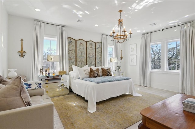 bedroom featuring light wood-type flooring and a chandelier