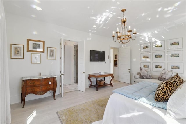 bedroom featuring an inviting chandelier and light hardwood / wood-style floors