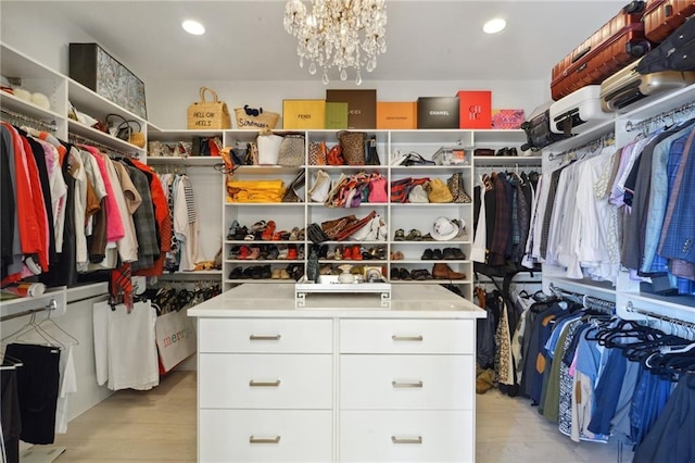 walk in closet with a chandelier and light wood-type flooring