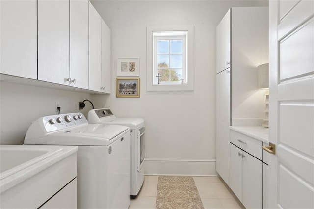 laundry room featuring cabinets, washer and clothes dryer, and light tile patterned floors