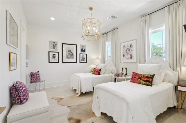 bedroom with an inviting chandelier and light hardwood / wood-style flooring