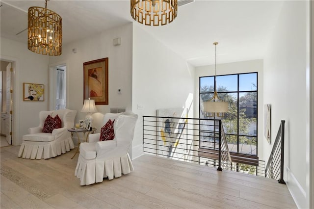 living area with a chandelier and light wood-type flooring