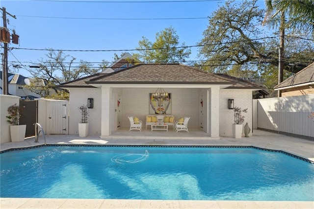 view of swimming pool featuring an outbuilding and a patio