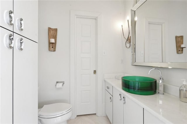 bathroom featuring tile patterned flooring, vanity, and toilet