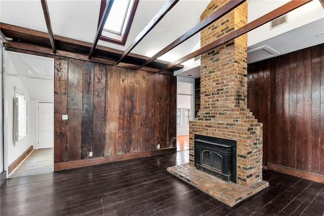 unfurnished living room with beamed ceiling, dark hardwood / wood-style floors, and wood walls