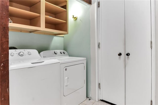 laundry area with washer and dryer and light tile patterned floors