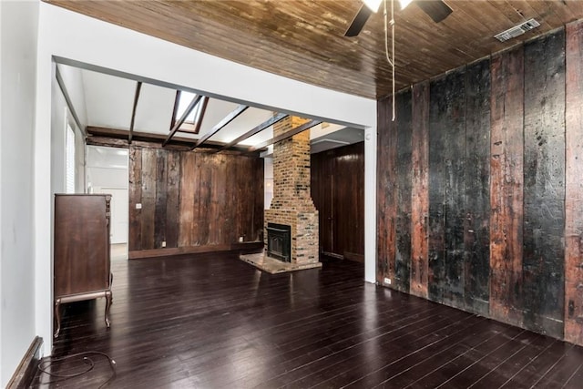 unfurnished living room with ceiling fan, wood walls, dark hardwood / wood-style flooring, and wooden ceiling