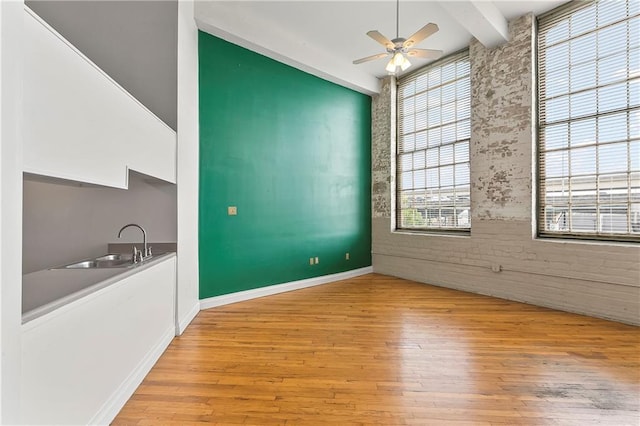 interior space featuring sink, light hardwood / wood-style floors, beamed ceiling, and ceiling fan