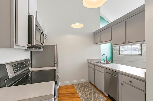 kitchen featuring sink, gray cabinets, stainless steel appliances, and light hardwood / wood-style floors