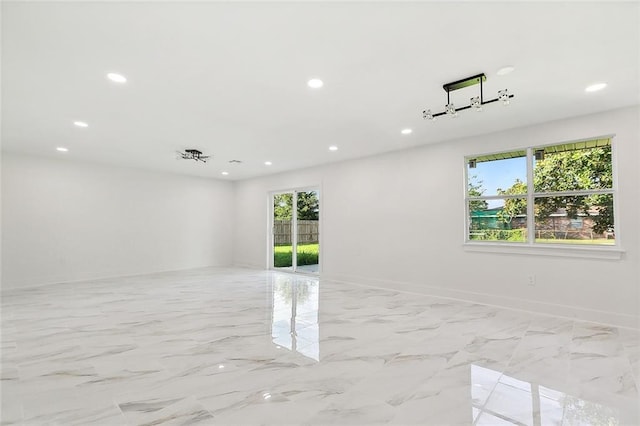 unfurnished room with recessed lighting, marble finish floor, and baseboards