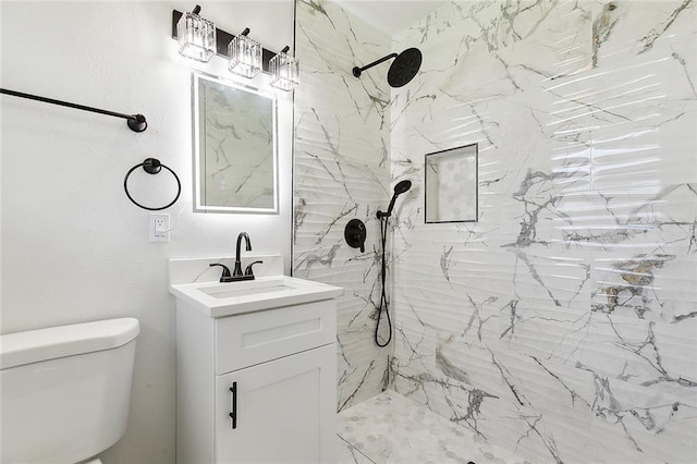 bathroom featuring a marble finish shower, toilet, and vanity