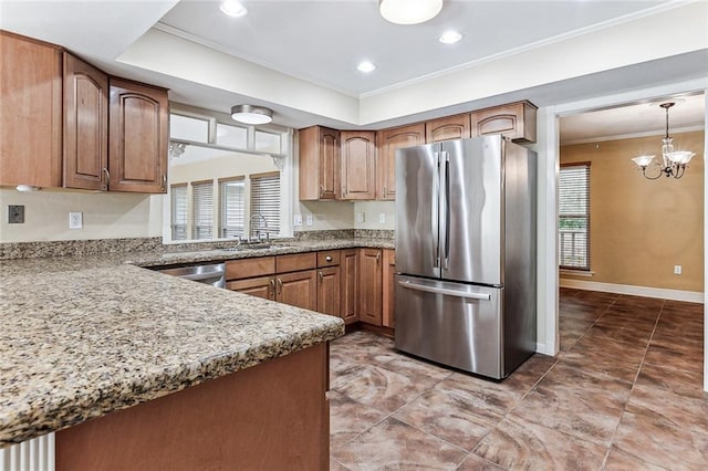 109 Lefleur Dr, Slidell, LA 70460 - kitchen featuring freestanding refrigerator, ornamental molding, a chandelier, brown cabinetry, and light stone countertops