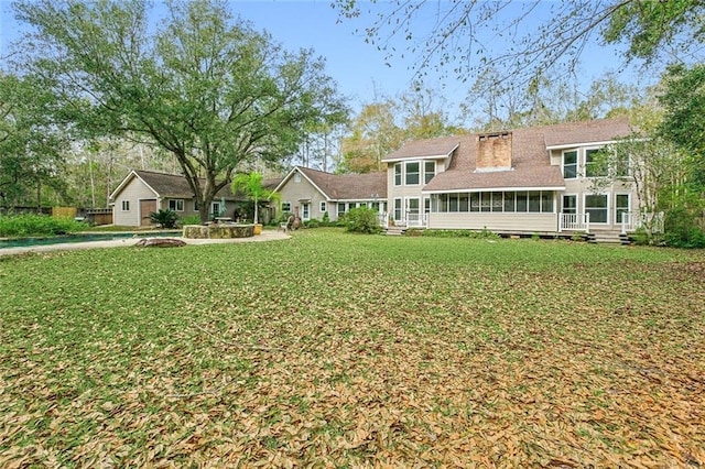 back of house featuring a yard and a sunroom