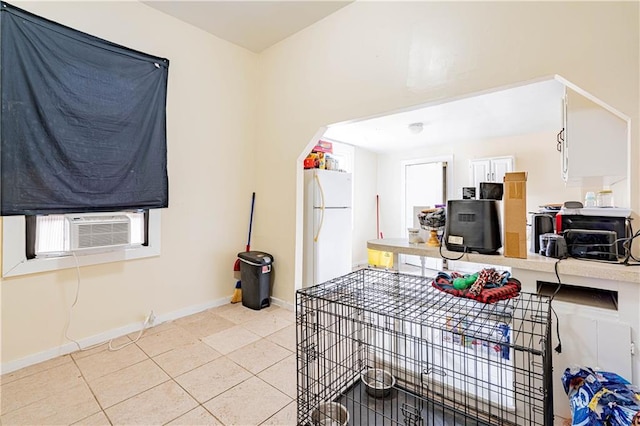 kitchen featuring white cabinetry, light tile patterned floors, cooling unit, and white fridge