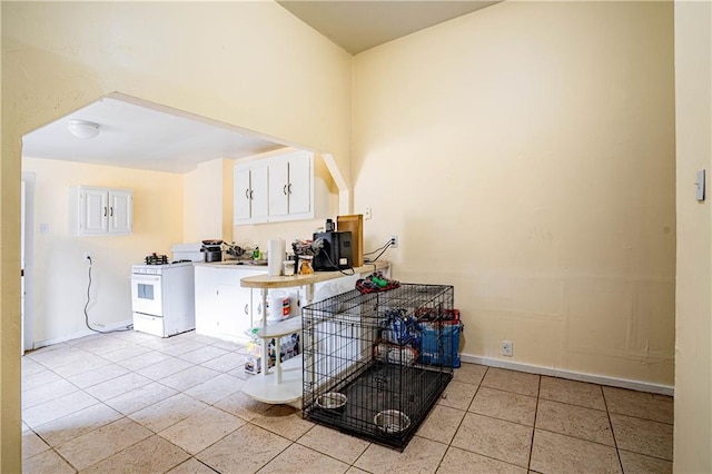 kitchen featuring white cabinetry, white gas stove, and light tile patterned floors