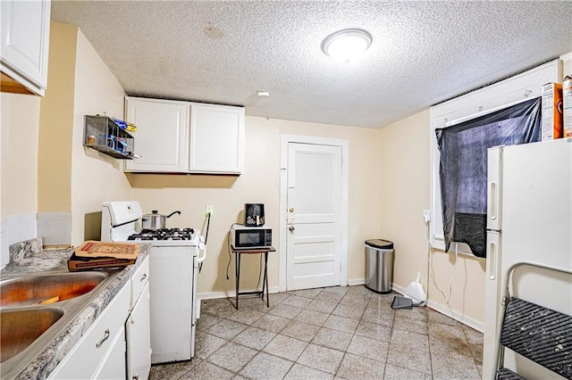 kitchen with white cabinetry, white appliances, sink, and a textured ceiling