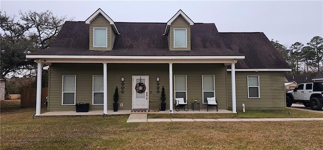 new england style home with a porch and a front yard